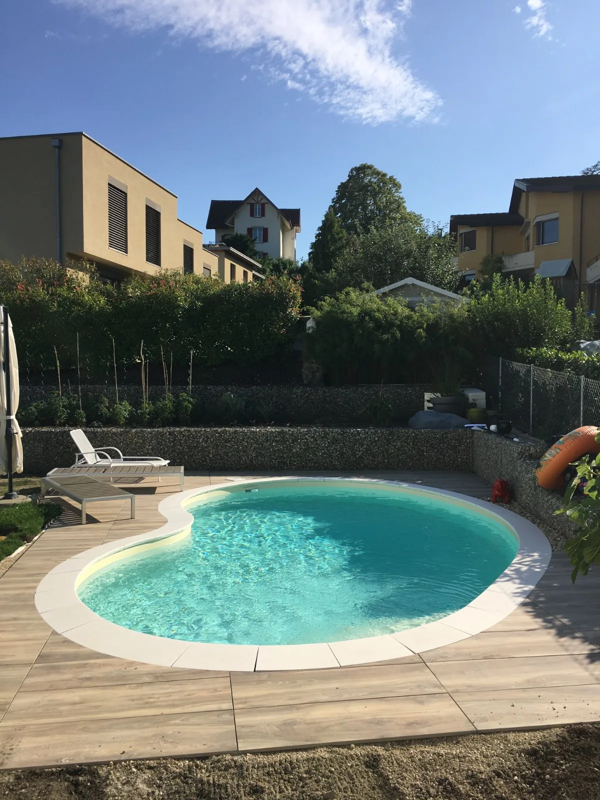 Piscine haricot bordée d’une terrasse en bois, réalisation Magicpool