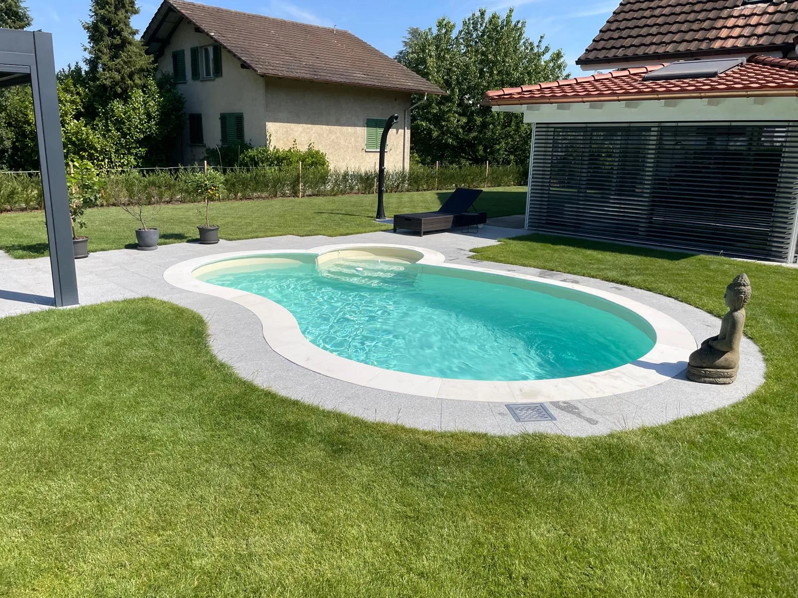 Piscine haricot devant une maison avec pergola, réalisation Magicpool