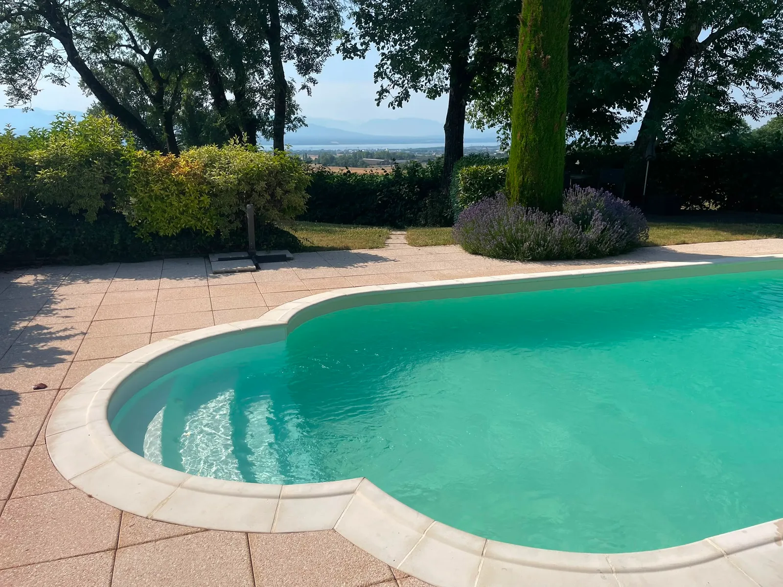 Piscine haricot sur une terrasse en travertin, réalisation Magicpool